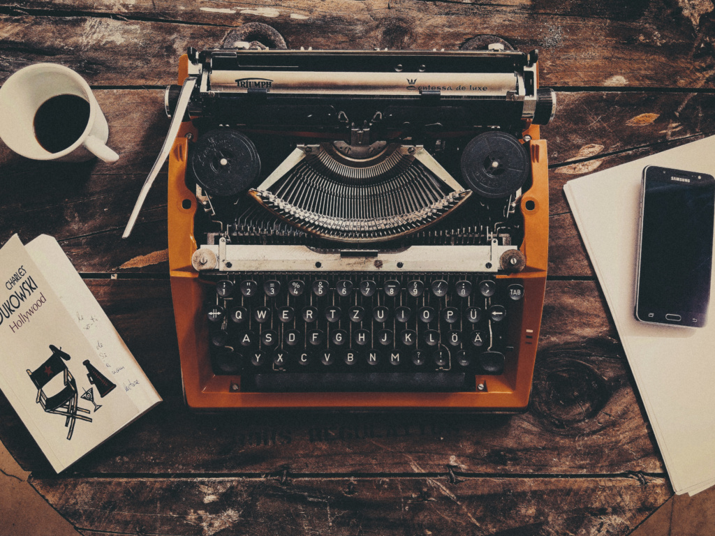 Yellow typewriter on desk with Charles Bukowski book